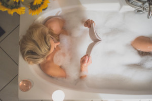 Girl Reading Whist Relaxing In A Bubble Bath tub_