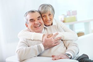 Portrait of a happy senior woman embracing her husband and both looking at camera