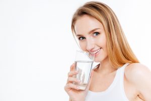 Pretty woman drinking water isolated on a white background