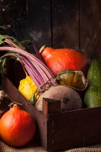 Colorful pumpkins and fresh beet in box on sackcloth