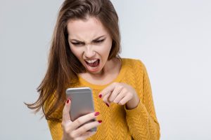 Portrait of angry woman screaming on the phone isolated on a white background